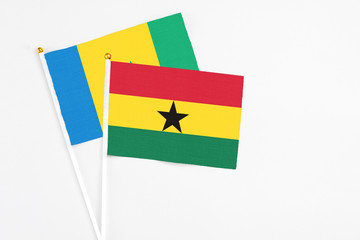 Ghana and Saint Vincent And The Grenadines stick flags on white background. High quality fabric, miniature national flag. Peaceful global concept.White floor for copy space.