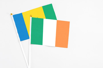 Fototapeta premium Ireland and Saint Vincent And The Grenadines stick flags on white background. High quality fabric, miniature national flag. Peaceful global concept.White floor for copy space.