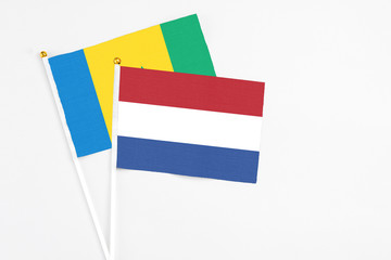Netherlands and Saint Vincent And The Grenadines stick flags on white background. High quality fabric, miniature national flag. Peaceful global concept.White floor for copy space.