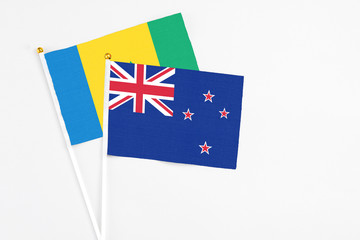 Fototapeta premium New Zealand and Saint Vincent And The Grenadines stick flags on white background. High quality fabric, miniature national flag. Peaceful global concept.White floor for copy space.
