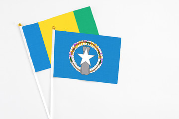 Northern Mariana Islands and Saint Vincent And The Grenadines stick flags on white background. High quality fabric, miniature national flag. Peaceful global concept.White floor for copy space.