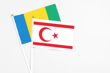 Northern Cyprus and Saint Vincent And The Grenadines stick flags on white background. High quality fabric, miniature national flag. Peaceful global concept.White floor for copy space.