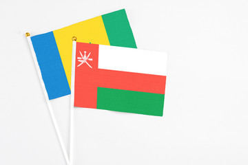 Oman and Saint Vincent And The Grenadines stick flags on white background. High quality fabric,...