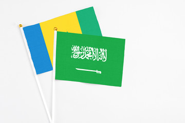 Saudi Arabia and Saint Vincent And The Grenadines stick flags on white background. High quality fabric, miniature national flag. Peaceful global concept.White floor for copy space.