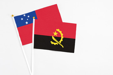 Angola and Samoa stick flags on white background. High quality fabric, miniature national flag. Peaceful global concept.White floor for copy space.