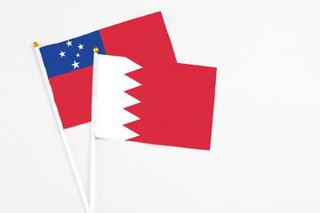 Bahrain and Samoa stick flags on white background. High quality fabric, miniature national flag. Peaceful global concept.White floor for copy space.