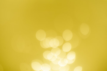 Yellow Gold Festive Christmas Beautiful abstract Background with bokeh lights. Holiday Texture with copy space. Can be used as Wallpaper, filling for a website, defocused