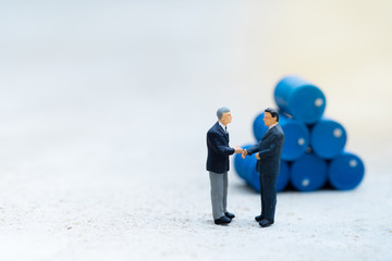 Miniature People : Two business man standing in front of drums pile with copy space, industrial concept, use as wallpaper