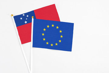 European Union and Samoa stick flags on white background. High quality fabric, miniature national flag. Peaceful global concept.White floor for copy space.