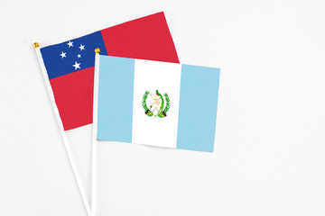 Guatemala and Samoa stick flags on white background. High quality fabric, miniature national flag. Peaceful global concept.White floor for copy space.