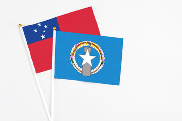 Northern Mariana Islands and Samoa stick flags on white background. High quality fabric, miniature national flag. Peaceful global concept.White floor for copy space.