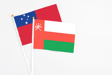 Oman and Samoa stick flags on white background. High quality fabric, miniature national flag. Peaceful global concept.White floor for copy space.