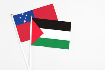 Palestine and Samoa stick flags on white background. High quality fabric, miniature national flag. Peaceful global concept.White floor for copy space.