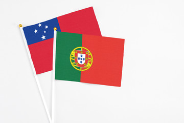 Portugal and Samoa stick flags on white background. High quality fabric, miniature national flag. Peaceful global concept.White floor for copy space.