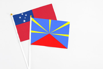 Reunion and Samoa stick flags on white background. High quality fabric, miniature national flag. Peaceful global concept.White floor for copy space.