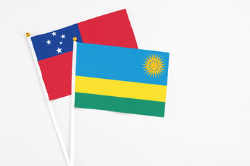 Rwanda and Samoa stick flags on white background. High quality fabric, miniature national flag. Peaceful global concept.White floor for copy space.