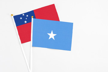 Somalia and Samoa stick flags on white background. High quality fabric, miniature national flag. Peaceful global concept.White floor for copy space.