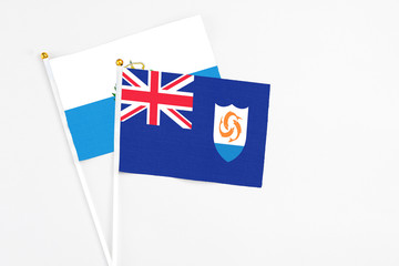 Fototapeta premium Anguilla and San Marino stick flags on white background. High quality fabric, miniature national flag. Peaceful global concept.White floor for copy space.