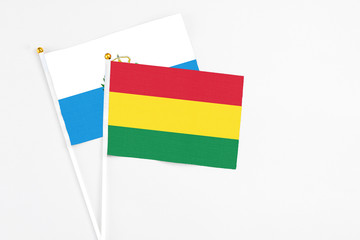 Bolivia and San Marino stick flags on white background. High quality fabric, miniature national flag. Peaceful global concept.White floor for copy space.