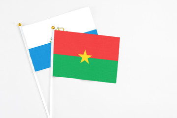 Burkina Faso and San Marino stick flags on white background. High quality fabric, miniature national flag. Peaceful global concept.White floor for copy space.