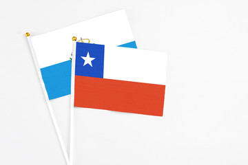 Chile and San Marino stick flags on white background. High quality fabric, miniature national flag. Peaceful global concept.White floor for copy space.