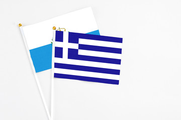 Obraz premium Greece and San Marino stick flags on white background. High quality fabric, miniature national flag. Peaceful global concept.White floor for copy space.