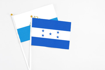 Honduras and San Marino stick flags on white background. High quality fabric, miniature national flag. Peaceful global concept.White floor for copy space.