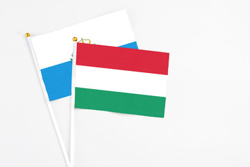 Hungary and San Marino stick flags on white background. High quality fabric, miniature national flag. Peaceful global concept.White floor for copy space.