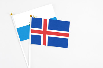 Obraz premium Iceland and San Marino stick flags on white background. High quality fabric, miniature national flag. Peaceful global concept.White floor for copy space.