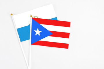 Puerto Rico and San Marino stick flags on white background. High quality fabric, miniature national flag. Peaceful global concept.White floor for copy space.