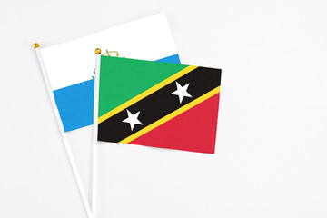 Saint Kitts And Nevis and San Marino stick flags on white background. High quality fabric,...