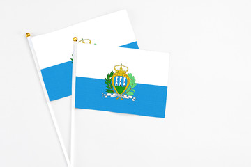 San Marino and San Marino stick flags on white background. High quality fabric, miniature national flag. Peaceful global concept.White floor for copy space.