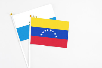 Venezuela and San Marino stick flags on white background. High quality fabric, miniature national flag. Peaceful global concept.White floor for copy space.