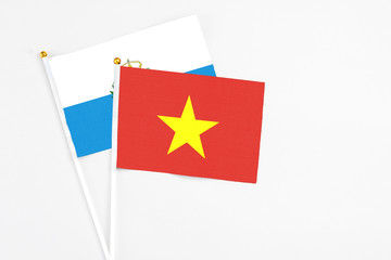 Vietnam and San Marino stick flags on white background. High quality fabric, miniature national flag. Peaceful global concept.White floor for copy space.