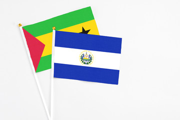 El Salvador and Sao Tome And Principe stick flags on white background. High quality fabric, miniature national flag. Peaceful global concept.White floor for copy space.