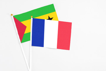 France and Sao Tome And Principe stick flags on white background. High quality fabric, miniature national flag. Peaceful global concept.White floor for copy space.