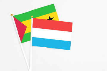 Luxembourg and Sao Tome And Principe stick flags on white background. High quality fabric, miniature national flag. Peaceful global concept.White floor for copy space.