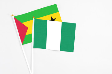 Nigeria and Sao Tome And Principe stick flags on white background. High quality fabric, miniature national flag. Peaceful global concept.White floor for copy space.