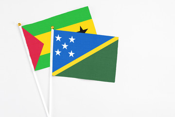 Solomon Islands and Sao Tome And Principe stick flags on white background. High quality fabric, miniature national flag. Peaceful global concept.White floor for copy space.