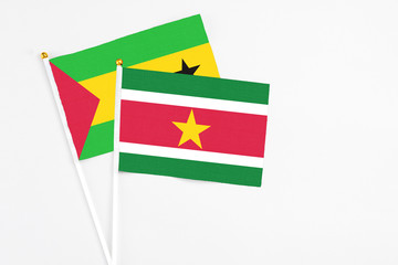 Suriname and Sao Tome And Principe stick flags on white background. High quality fabric, miniature national flag. Peaceful global concept.White floor for copy space.