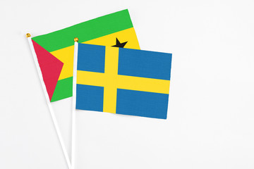 Sweden and Sao Tome And Principe stick flags on white background. High quality fabric, miniature national flag. Peaceful global concept.White floor for copy space.
