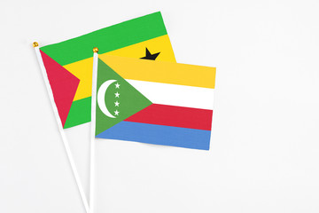 Comoros and Saudi Arabia stick flags on white background. High quality fabric, miniature national flag. Peaceful global concept.White floor for copy space.