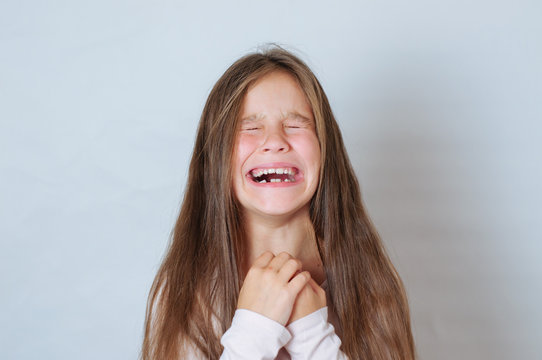 Emotional portrait of strong emotions tears of a little beautiful girl on a white background