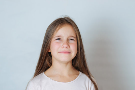 Emotional portrait of strong emotions tears of a little beautiful girl on a white background