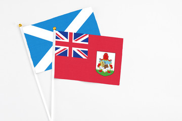 Bermuda and Scotland stick flags on white background. High quality fabric, miniature national flag. Peaceful global concept.White floor for copy space.