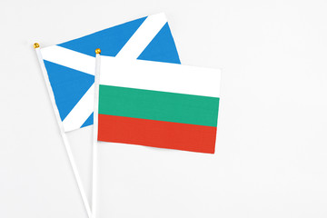 Bulgaria and Scotland stick flags on white background. High quality fabric, miniature national flag. Peaceful global concept.White floor for copy space.