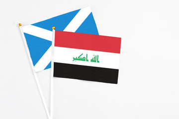Iraq and Scotland stick flags on white background. High quality fabric, miniature national flag. Peaceful global concept.White floor for copy space.