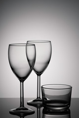 Set of wineglasses on a glass table on light grey background