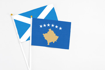 Kosovo and Scotland stick flags on white background. High quality fabric, miniature national flag. Peaceful global concept.White floor for copy space.