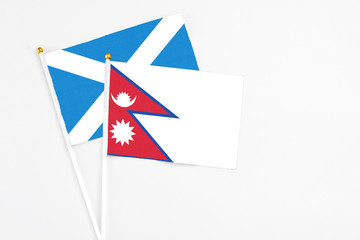 Nepal and Scotland stick flags on white background. High quality fabric, miniature national flag. Peaceful global concept.White floor for copy space.